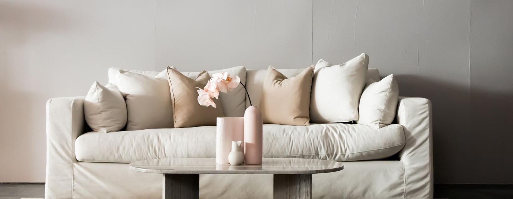 living room with a large couch and vases on a coffee table