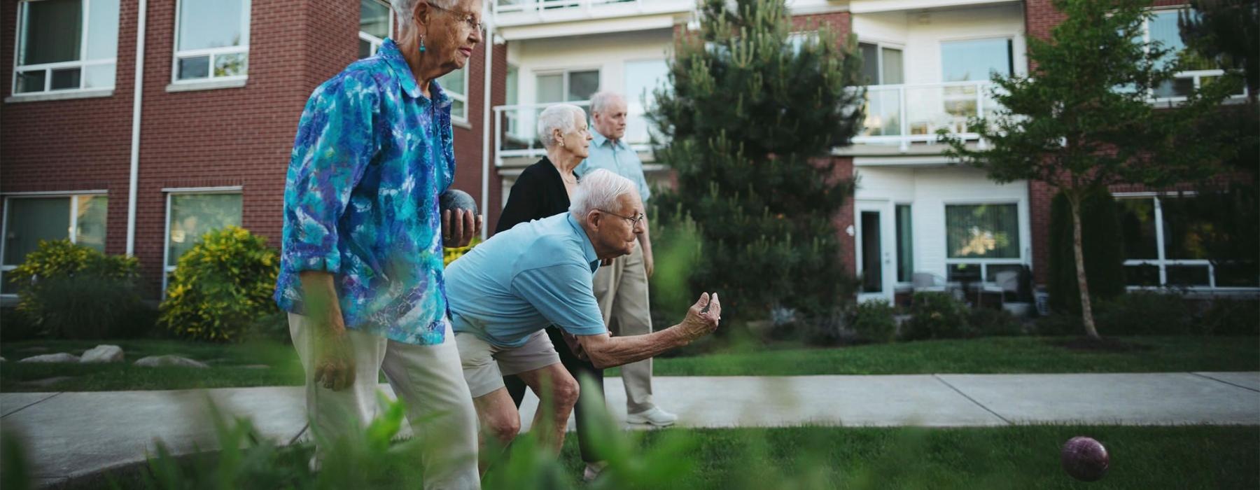 a group of people playing with a ball in front of a building